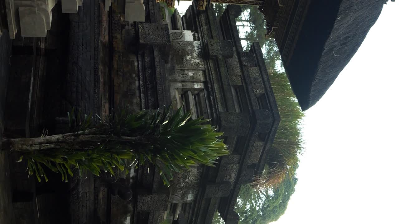 Vertical slow motion panning shot of temple building at pura tirta empul water temple on bali Indonesia in ubud during an adventurous journey