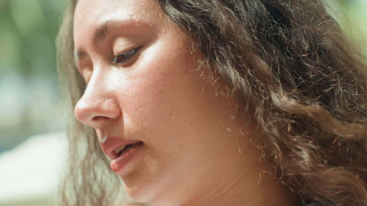 Closeup woman face near palms, beachside blogger filming candid clip on island shore, gentle breeze, sun shimmer on skin, relaxed smile, tropical warmth, vacation vibe, candid framing