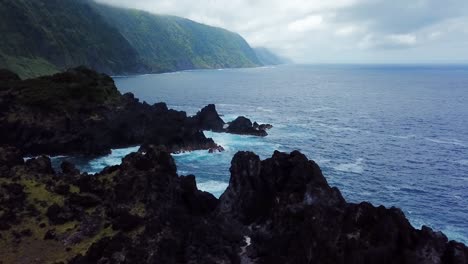 aerial shot above fajã do ouvidor in são jorge island, towards to the rocky blue coast