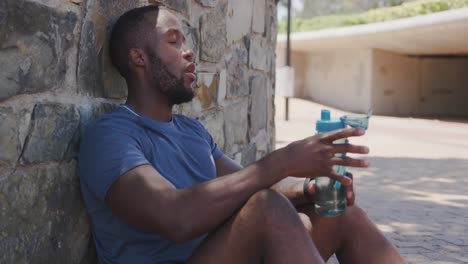 man training in an urban setting taking a break