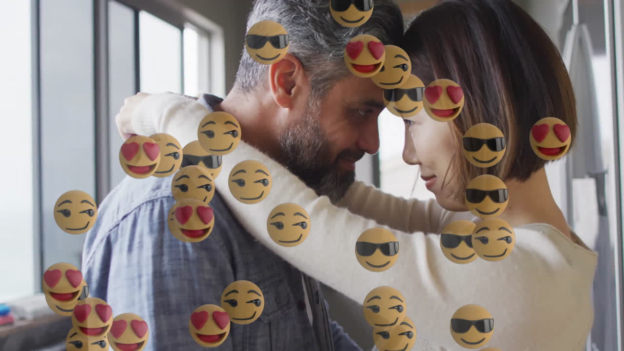 Couple pressing foreheads in kitchen, showing floating emoji overlays for social media marketing