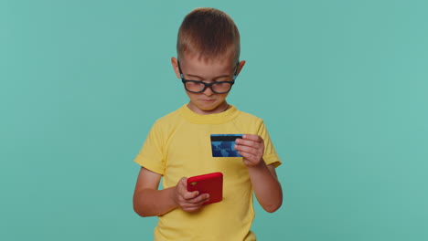 Children-boy-using-credit-bank-card,-smartphone-while-transferring-money,-purchases-online-shopping