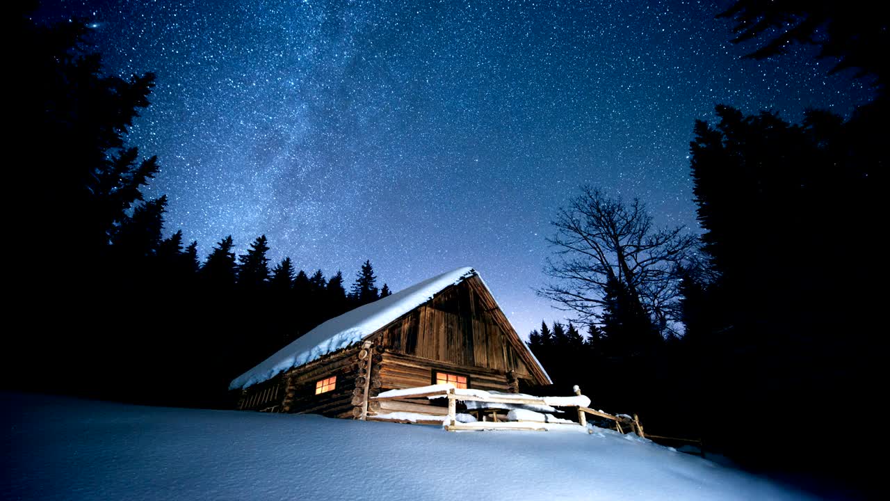 time-lapse. hermosa casa de madera en el bosque de invierno bajo las estrellas