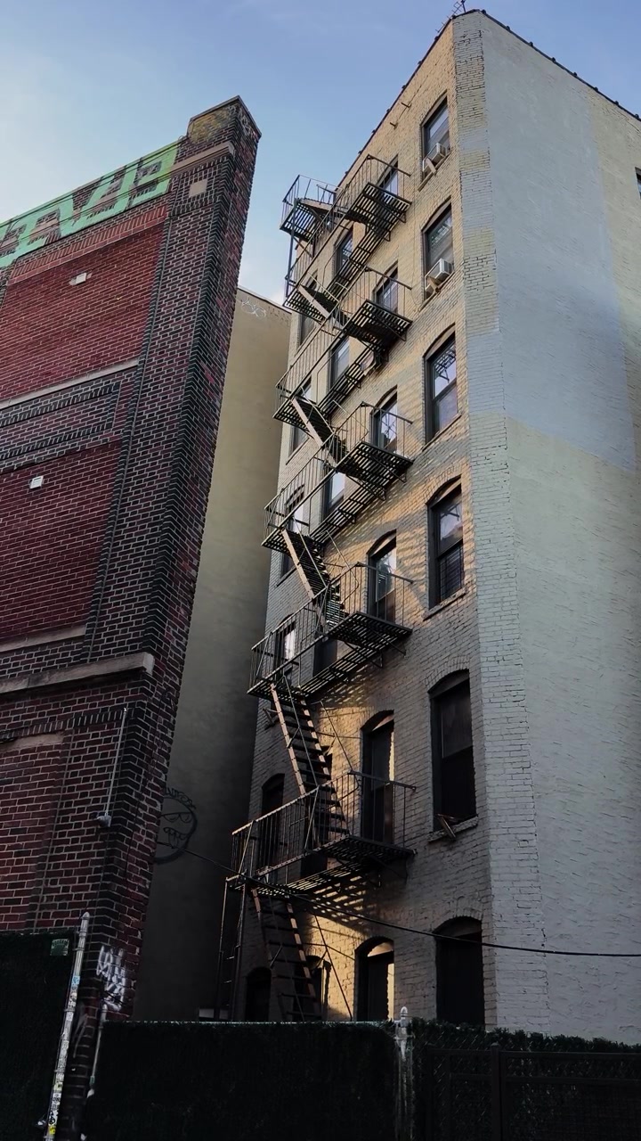 Vista dal basso di un condominio urbano con scala antincendio alla luce del sole serale