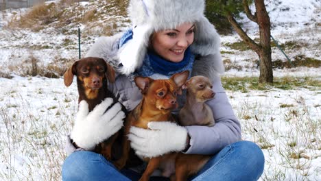 woman playing with her little dogs outside winter