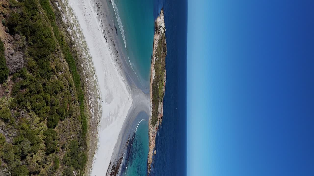 drone vertical hacia atrás toma de la isla de diamantes con playa de arena en la costa de tasmania en verano