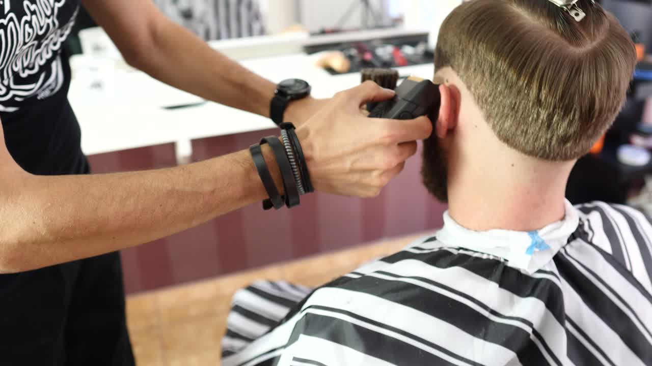 peluquero corta el cabello del cliente