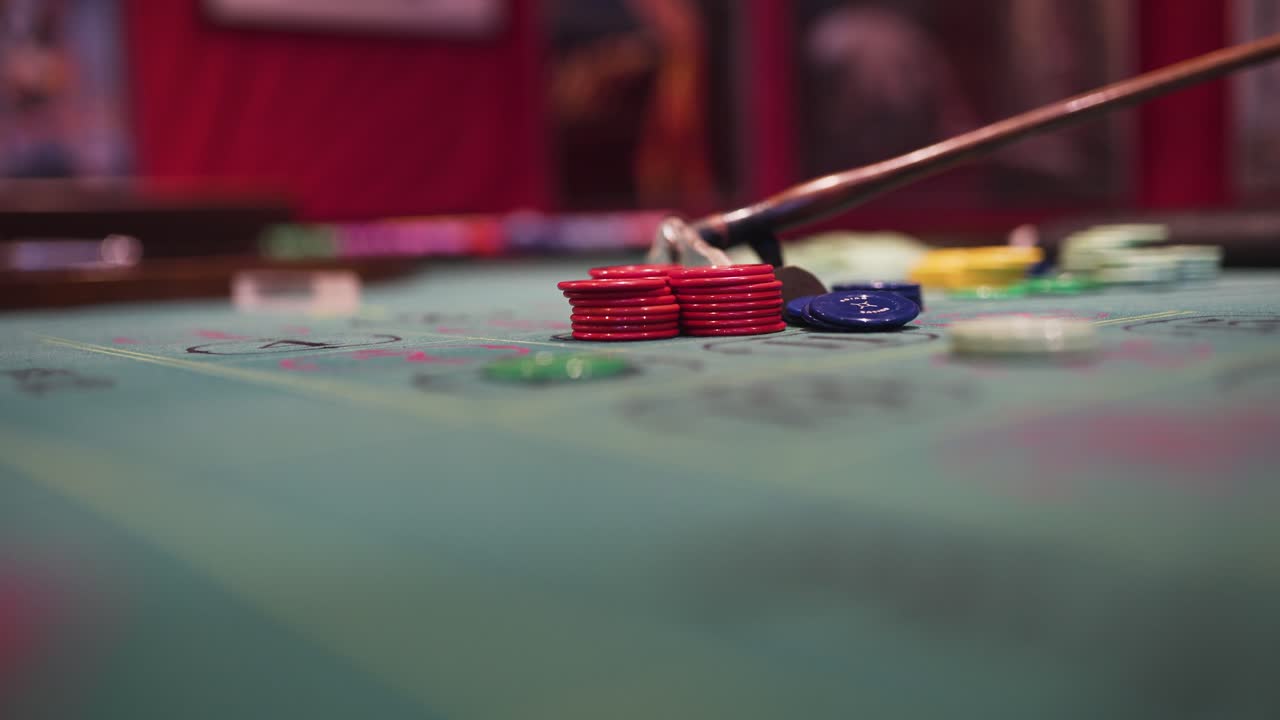 un crupier está manejando las fichas en una mesa de ruleta con su rastrillo mientras la rueda gira-1