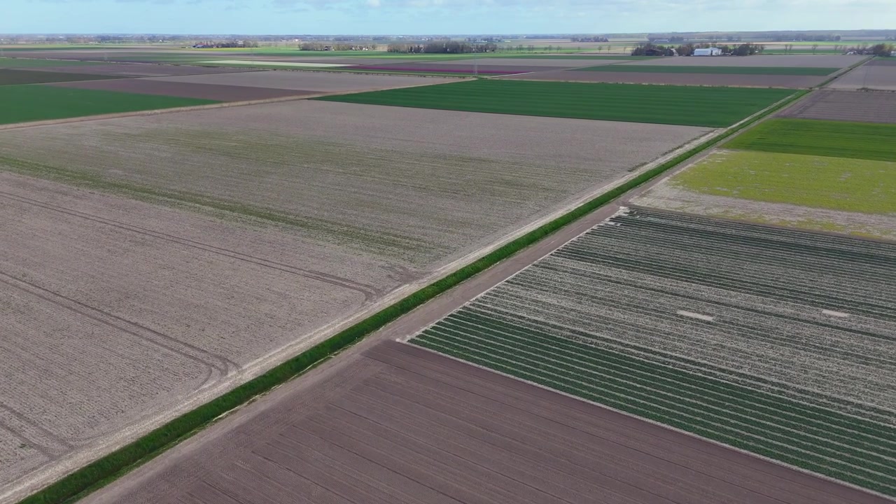 Drone footage of the Dutch village of Ens, Noordoostpolder, Flevoland, the Netherlands. Patches of agricultural land