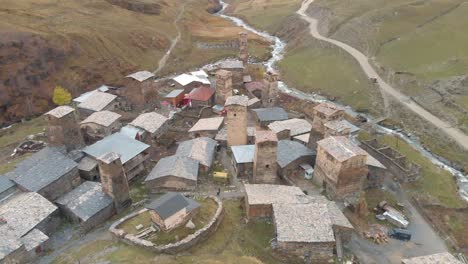 looking down on a small river valley village made of stone in the svaneti region of georgia