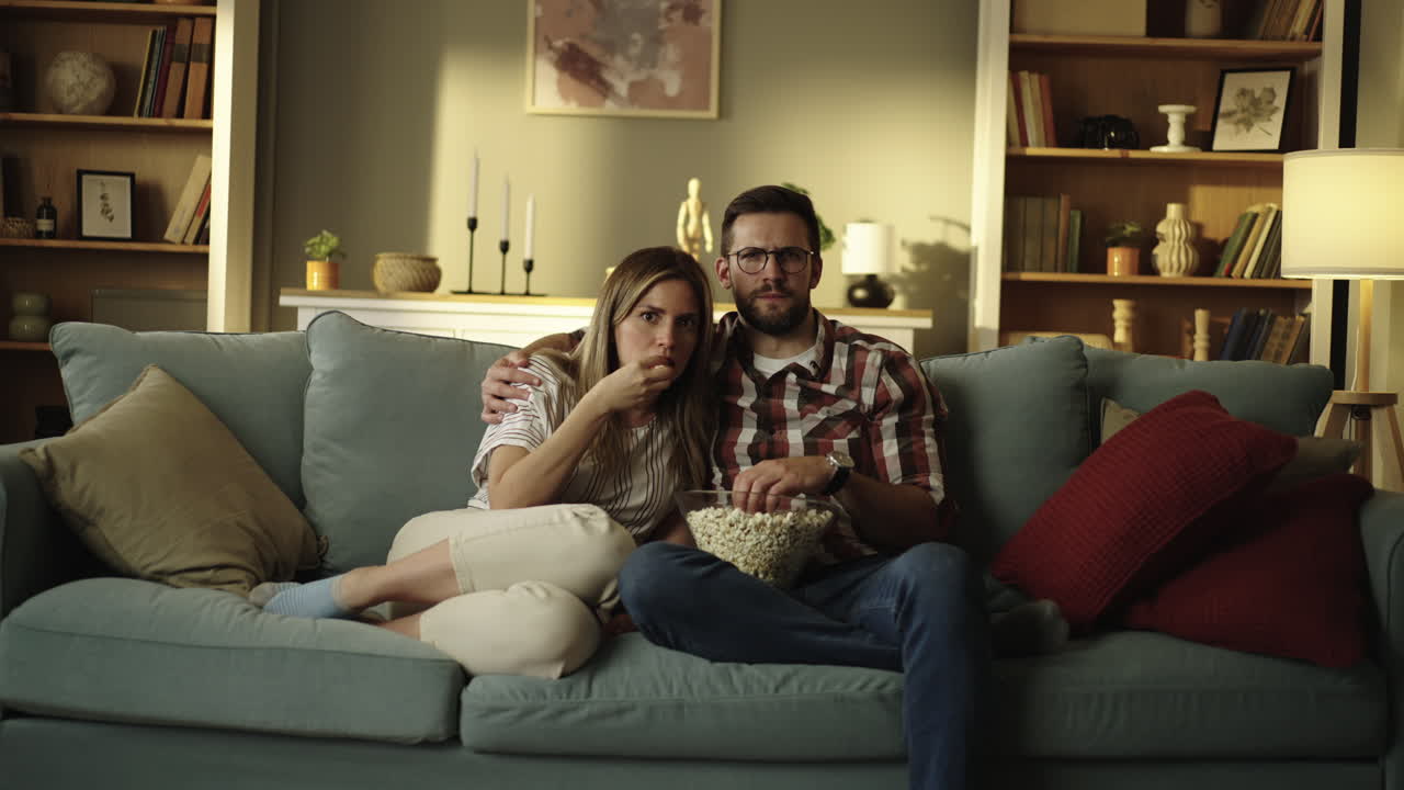 pareja viendo una película en casa