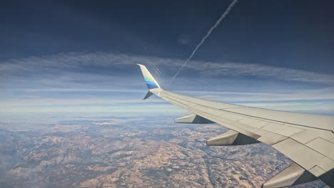 airplane window seat view overlooking to sierra nevada mountains