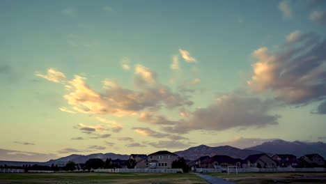 Sunset-cloudscape-over-a-suburban-neighborhood-with-mountains-in-the-distance---static-time-lapse