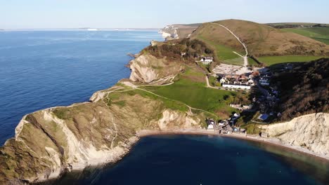 Aerial-forward-shot-of-Lulworth-Cove-and-Stair-Hole-in-Dorset-England