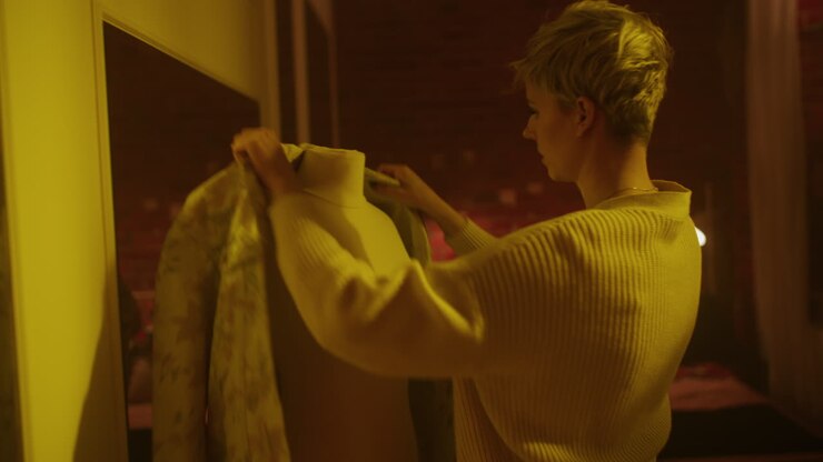 Donna che prova vestiti in una camera da letto