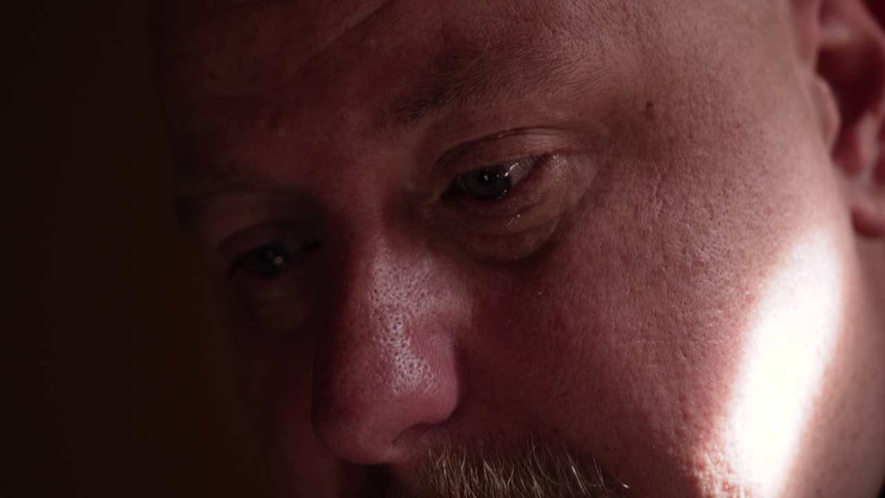 슬프고, 불행하고, 슬퍼하고, 울고 있는 남자가 아파트에서 혼자  ⁇ 드폰을 보고 있습니다.