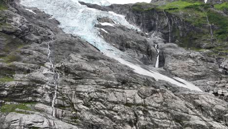 Boyabreen-Gletscher-–-Zunge-Und-Rand-Des-Jostedal-Gletschers-In-Fjærland,-Norwegen-–-Sich-Nach-Oben-Bewegende-Luftaufnahme,-Die-Den-Vollständigen-Blick-Auf-Den-Gletscher-Mit-Einem-Strom-Aus-Geschmolzenem-Gletscherwasser-Auf-Der-Rechten-Seite-Freigibt-–-60-Bilder-Pro-Sekunde