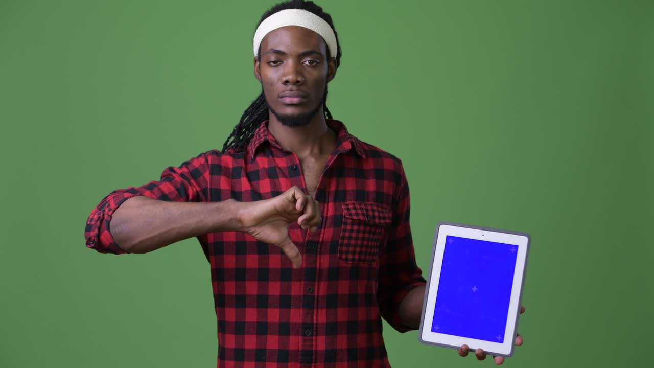 Young handsome African man with dreadlocks against green background