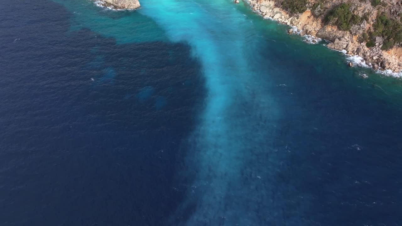 Onde blu si infrangono dolcemente lungo la spiaggia di Agiofili sulla costa ionica.