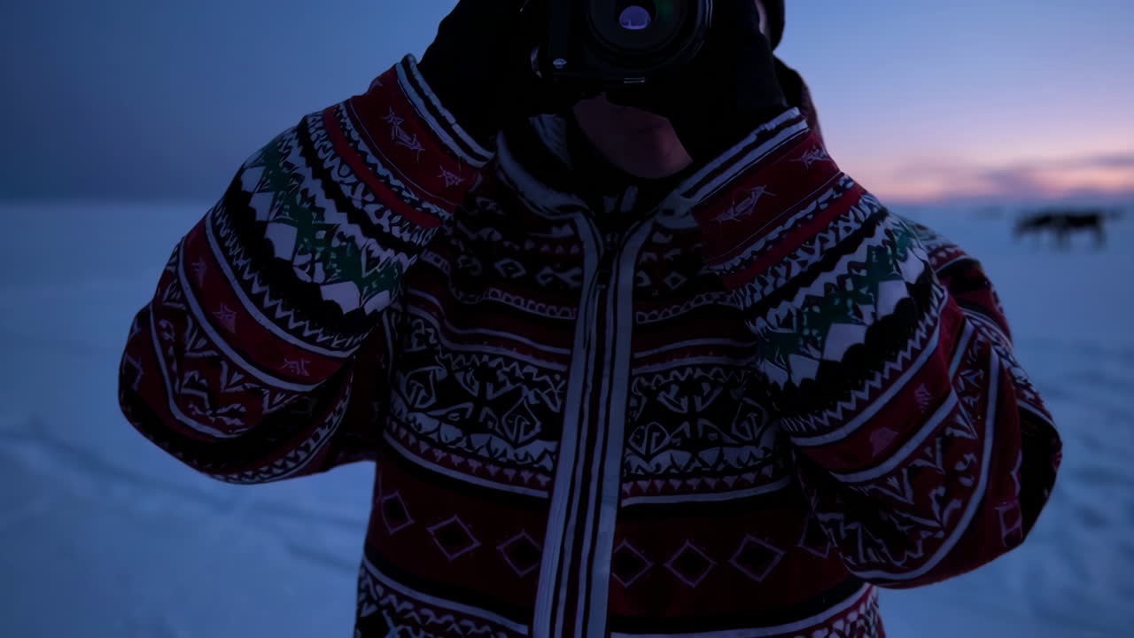 Photographer capturing winter landscape at sunset