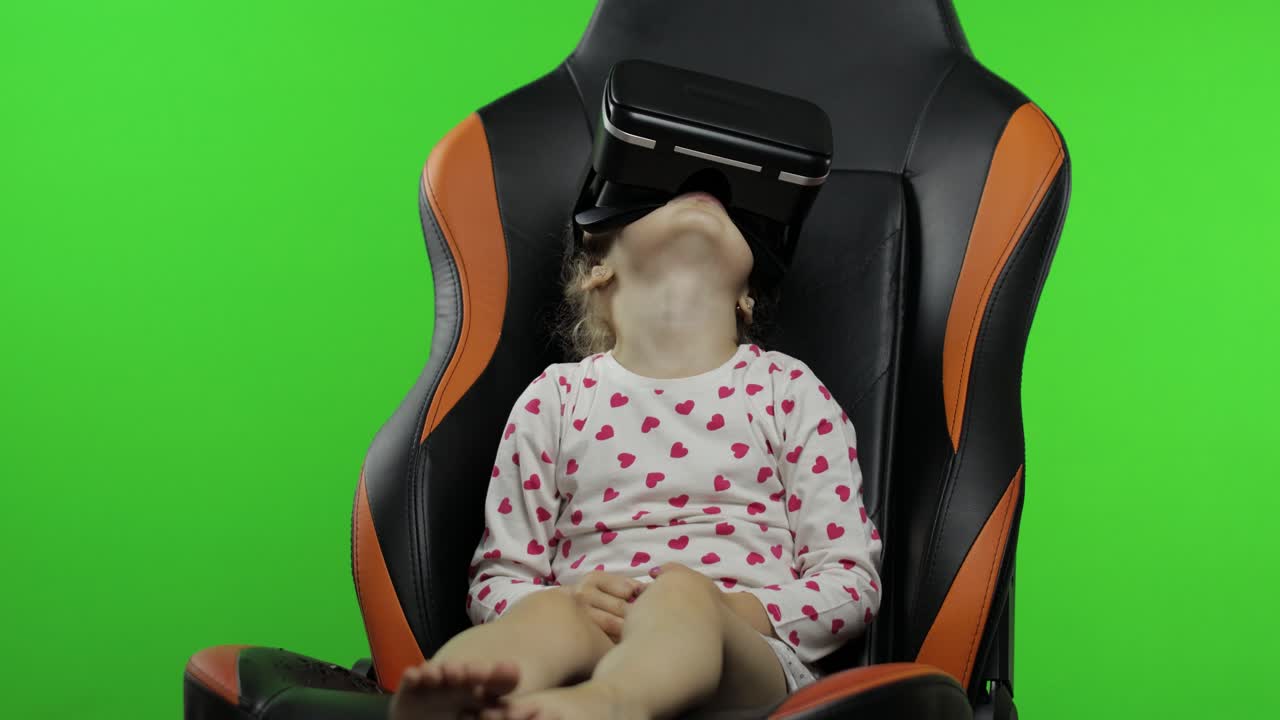 niña usando casco vr para jugar a una aplicación de juego de simulación. vea video de realidad virtual 3d. clave de croma