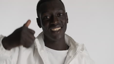 un hombre afroamericano sonriente sobre un fondo gris.