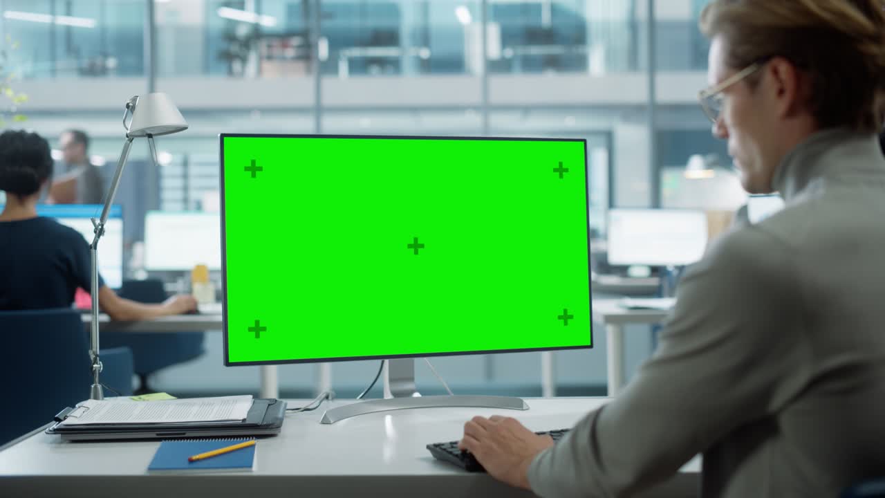크로마 키와 녹색 화면 모의 디스플레이를 가진 데스크 컴퓨터에서 일하는 사업가의 어깨 을 가까이 니다. 디지털 프로젝트 관리자가 키보드와 마우스를 사용하여 데이터를 입력합니다.