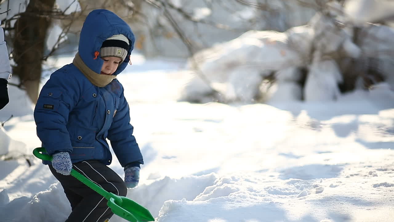 Kid playing in snow. Boy playing outdoors on a snowy winter day