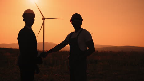 business deal at wind farm sunset