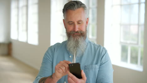 Trendiger-Mann,-Der-Sein-Telefon-Drinnen-Benutzt