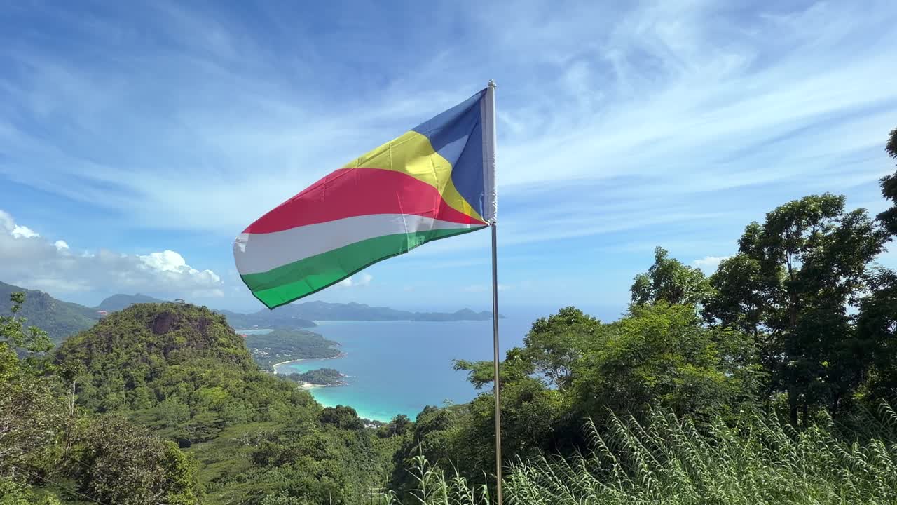 Bendera Nasional Seychelles Berkibar di atas Pemandangan Garis Pantai Barat Mahe yang Menakjubkan, 25fps 003
