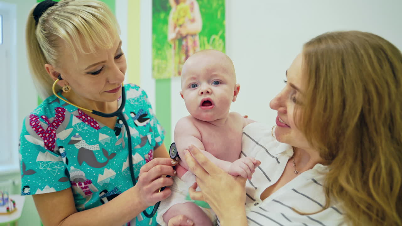 Female doctor examining baby in clinic. Doctor examining little baby with stethoscope in clinic