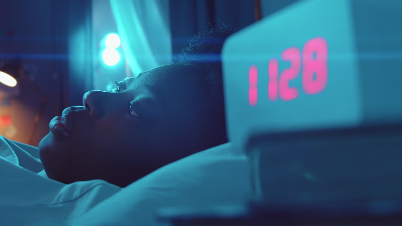 밤에 침대에서 전화를 사용하는 아프리카계 미국인 여성