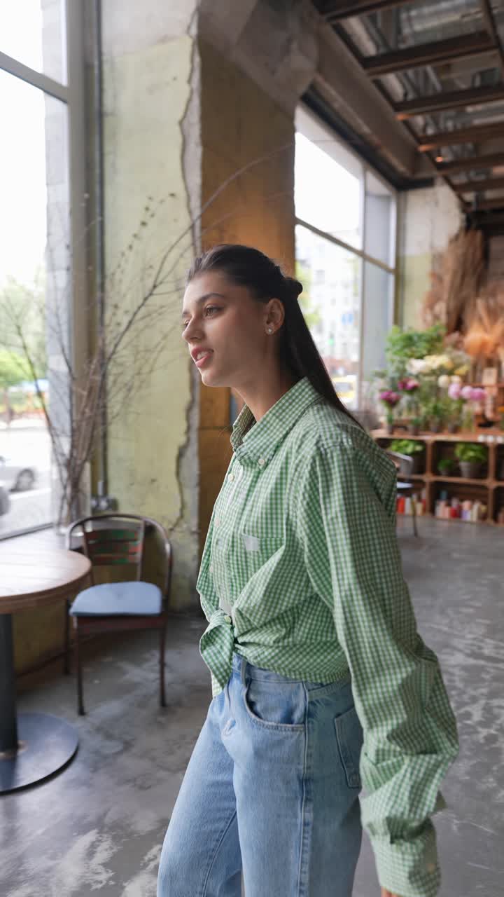 세련된 초록색 셔츠와 청바지를 입은 젊은 여성