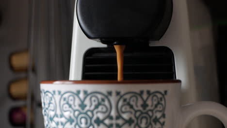 creamy brown coffee for breakfast dripping in a mug - extreme close up