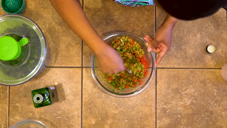 home chef mixes ingredients for homemade lip-smacking vegan kamut tabbouleh salad - overhead view