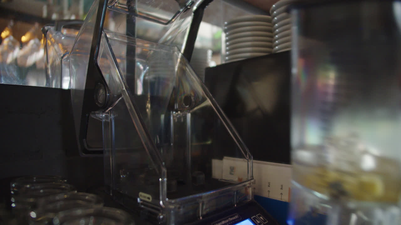 Beautiful slow motion shot while a blender glass is placed in the machine to crush the ingredients and prepare the piña colada cocktail, famous drink in Latin America and the Caribbean