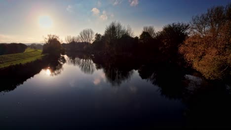 árboles de río y otoño durante la puesta de sol, video aéreo de drones