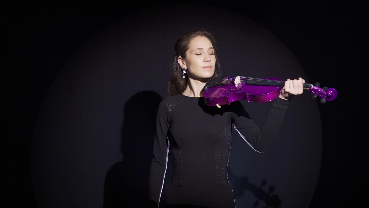 joven mujer músico en el escenario tocando el violín.