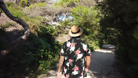 man walking through the dunes of cala agulla