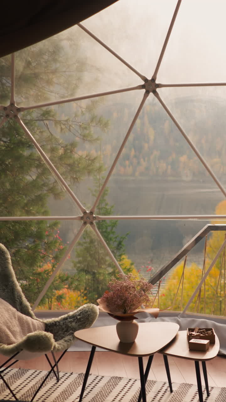 관광객을 위한 글램핑 하우스 테라스에서 점심을 먹을 수 있는 공간: 호수의 매혹적인 전망을 즐기기 위해 주변에 부드러운 의자가 있는 낮은 테이블, 빌릴 수 있는 글램핑 호텔 방