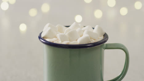 video of cup of hot chocolate with marshmallows over grey background