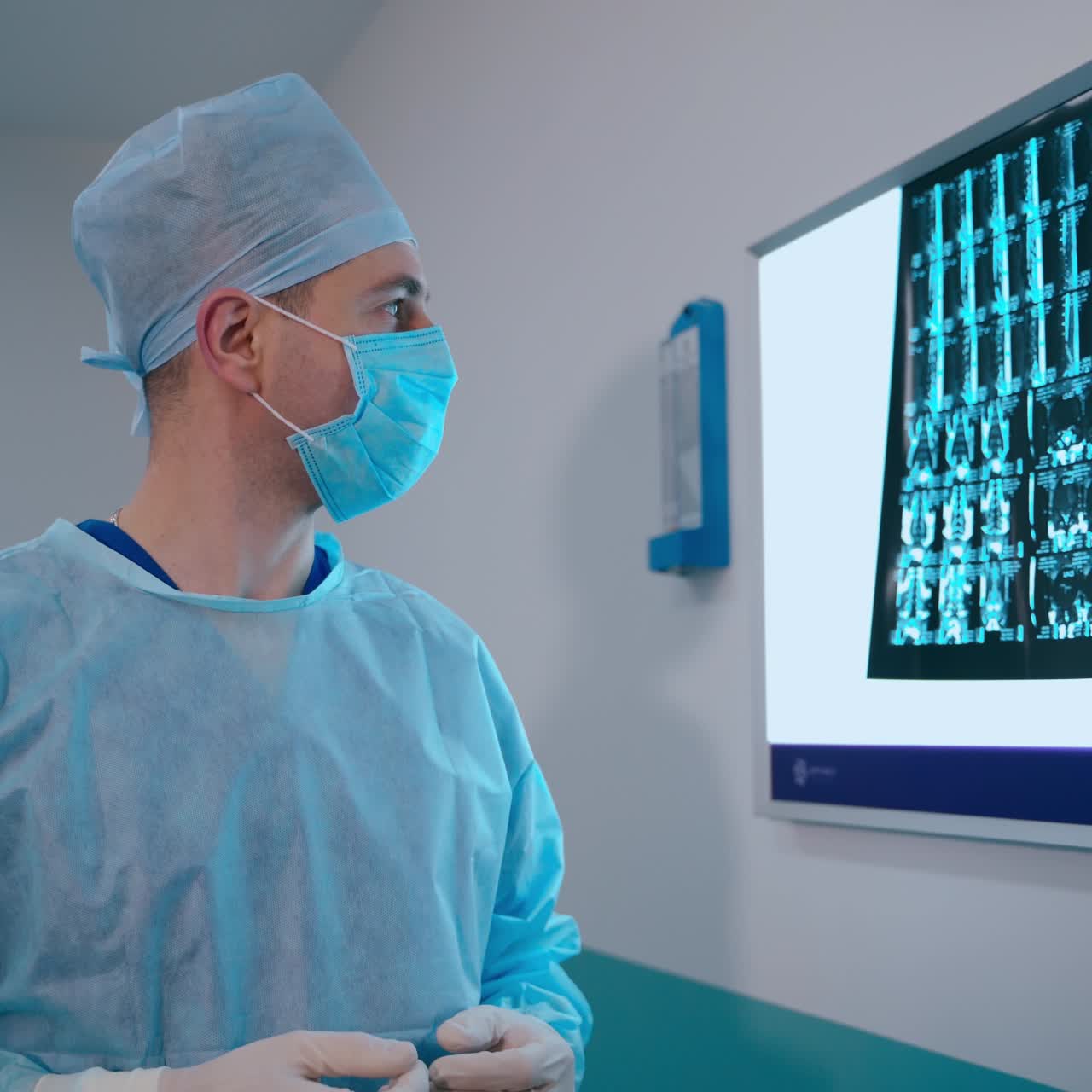 Doctor in medical uniform looking at x-ray in clinic. Specialist studying spine x-ray and coming to the medical microscope in a surgery room.