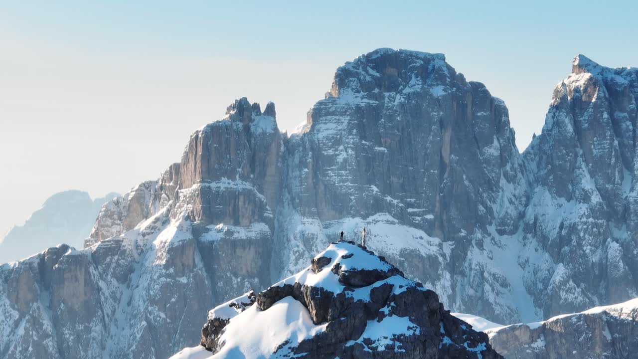 una persona de pie en una cumbre en invierno