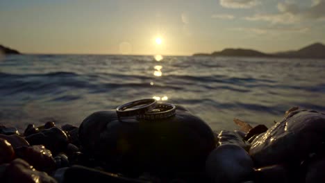 wedding rings by the sea at sunset