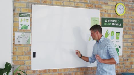 Caucasian-male-teacher-standing-at-whiteboard-giving-an-online-lesson-to-camera