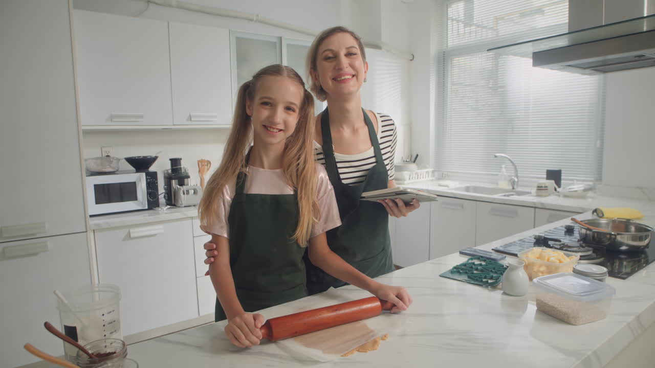 Madre e figlia felici che cucinano biscotti a casa