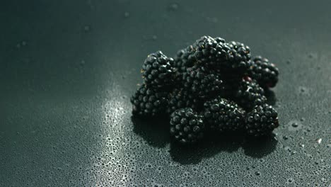 pile of shiny blackberries on wet surface