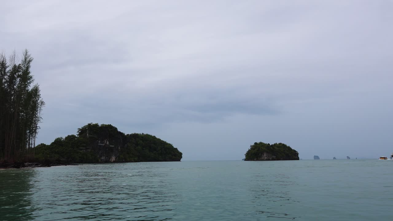 평온한 크라비 물에 있는 배와 섬