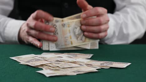 man counting polish zloty on table . a man in a business shirt is counting polish mon. man hands count polish banknotes